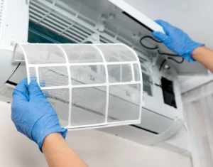 nettoyage des filtres d'une unité intérieure avec des gants bleus